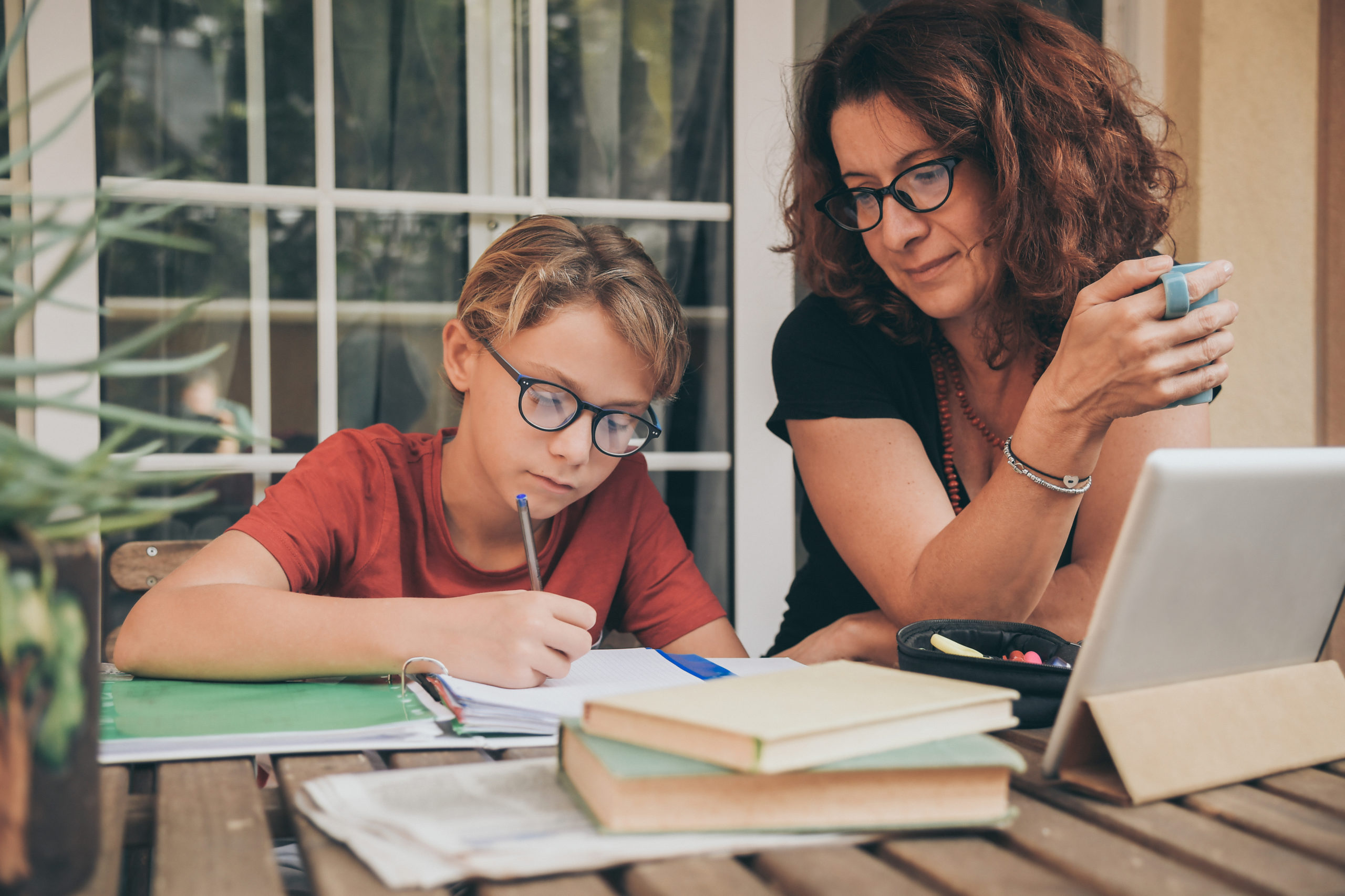 Mother helping son with his homework at table